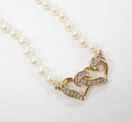 A modern single strand cultured pearl necklace, with central diamond chip set 14k yellow metal