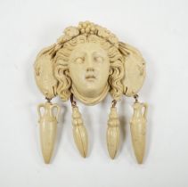 A yellow metal mounted lava drop brooch, modelled as the head of a lady flanked by ram's heads,