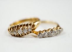 Two early 20th century 18ct gold and graduated five stone diamond set half hoop rings, gross