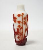 A Chinese ruby and white opaque glass erotic snuff bottle, early 20th century, 8cm high