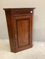 An early 19th century mahogany banded oak hanging corner cupboard, width 81cm, depth 48cm, height