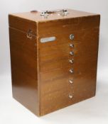 An early 20th century teak dental cabinet, glass lined drawers with chrome fittings, some dental
