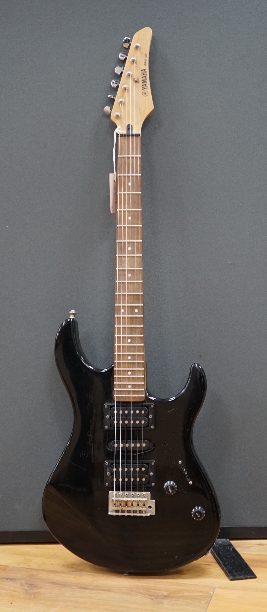 A Yamaha electric guitar, ERG 121, with black lacquer body and a small Carlsbro Kickstart practice