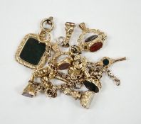 An early 20th century yellow metal charm bracelet (a.f.), hung with five assorted watch keys,