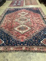 A North West Persian red ground carpet and a Belouch prayer rug, larger 300 x 216cm