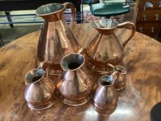 Six Victorian graduated copper flagon measures, one marked Farrow & Jackson, London, largest