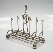 A late Victorian novelty silver toast rack, the dividers modelled as musical notes, with central