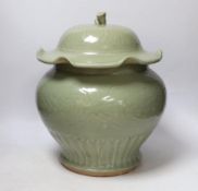 A large Chinese celadon jar and cover, Ming dynasty or later, the lotus leaf shaped cover above a
