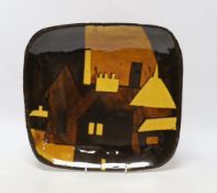 A slipware pottery plate, with abstract houses design, 31cm wide