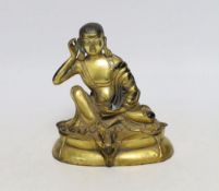 A Sino-Tibetan gilt bronze seated figure of Milarepa, 14cm high