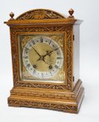 An Edwardian carved oak mantel clock with engraved dial, 33cm high