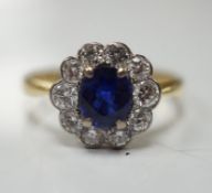 A modern 18ct gold, sapphire and diamond set circular cluster ring, size P/Q, gross weight 3.4