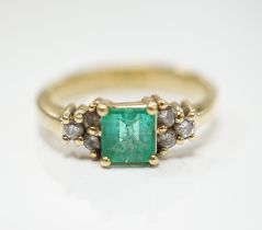 A modern 18k, emerald and diamond set cluster ring, size N, gross weight 3.8 grams.