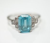 An 18ct, plat and single stone emerald cut blue zircon set ring, with six stone diamond set