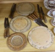 Three carved wood breadboards, a butter dish and a collection of knives with carved handles, largest