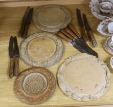 Three carved wood breadboards, a butter dish and a collection of knives with carved handles, largest