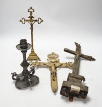 Three brass crucifixes and an Orivit pewter candlestick, tallest 45cm high