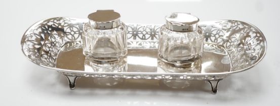 An Edwardian pierced silver inkstand, with two mounted glass wells, on four feet, Haseler