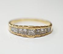 A modern 18ct gold and graduated nine stone princess cut diamond set half hoop ring, size L, gross