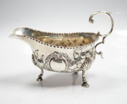 A George III silver sauce boat, with flying scroll handled and later embossed decoration, maker