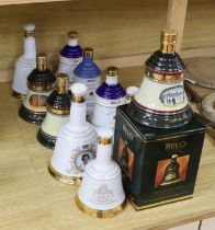 Eleven Wade pottery Bells whisky decanters with contents, one with box