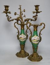 A pair of Sevres style porcelain and brass rococo-style two branch candelabra, hand painted with