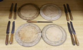 Four carved wood bread boards and a collection of knives with carved handles, boards 28cm in