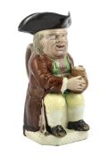 A Ralph Wood type creamware Toby jug of standard type, c.1790, seated in standard pose holding an