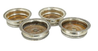 Two pairs of early 19th century silver mounted wine coasters, one pair by John Roberts & Co,