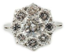 A modern 18ct white gold and round brilliant cut nine stone diamond set cluster ring, the centre