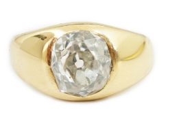 A George V 18ct gold and solitaire diamond gypsy set ring, the oval cushion cut stone measuring