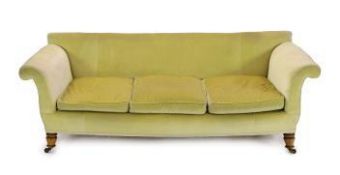A large Victorian style sofa in the manner of Howard & Sons, with faded velvet upholstery, on turned