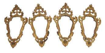 A set of four 19th century Italian giltwood wall mirrors of cartouche shape with pierced