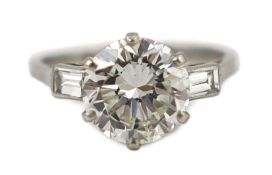 A good platinum or white gold set single stone diamond ring, with two stone baguette cut diamond set