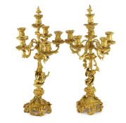 A pair of Victorian style ormolu six light candelabra with rococo scroll extinguishers, scrolling