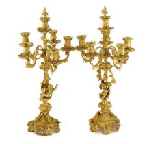 A pair of Victorian style ormolu six light candelabra with rococo scroll extinguishers, scrolling
