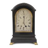 A late Victorian Georgian style ebonised eight day chiming bracket clock in arched case, the