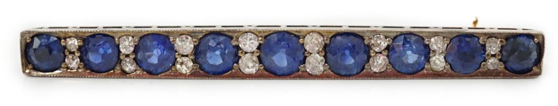 An Edwardian gold and graduated nine stone round cut sapphire set bar brooch, with round cut diamond