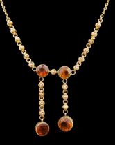 An Edwardian 15ct gold, seed pearl and citrine graduated double drop necklace, set with four round