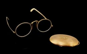 A pair of engraved gold mounted spectacles, with double hinged arms, unmarked, arm length 11.1cm,