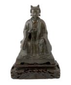 A Chinese bronze figure of a Daoist deity, late Ming, seated on a throne and holding a knotted