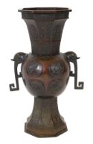A tall Japanese archaistic bronze octagonal vase, Meiji period, the ovoid body cast in relief with