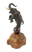 A Japanese bronze model of a rearing elephant standing on a ball, Meiji period, inset into a