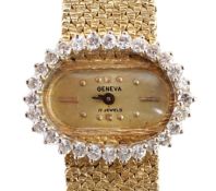 A lady's modern Swiss 14k gold and diamond set manual wind oval wrist watch, on integral 14k gold