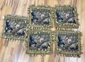 A set of five square woolwork cushion covers decorated with roses, and a bird, in greens, blues