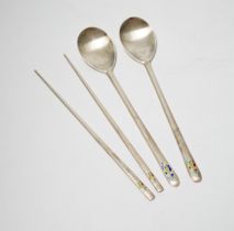 A Korean 990 standard white metal pair of chopsticks, 20cm and two matching spoons with enamelled