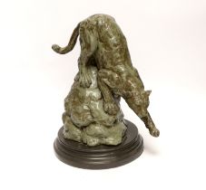 After Antoine Louis Barye, a patinated metal study of a leopard, raised on shaped circular base,