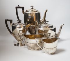 An Edwardian matched demi fluted silver five piece tea and coffee service, by Walker & Hall,