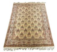 A North West Persian ivory ground carpet, woven with rows of flowering urns, 400 x 298cm