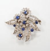 A white metal (stamped 18 plat), sapphire and diamond chip cluster set foliate brooch, 32mm, gross
